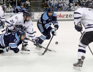 New Hampshire's Nick Sorkin (21) works to control a face off against Maine's Jon Swavely (18) and Steven Swavely (11) during the first period of an NCAA college hockey game at the Whittemore Center, Saturday, March 9, 2013 in Durham, N.H. (AP Photo/Jim Cole)