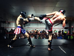 Derek Shorey (left) blocks a kick from Alex Clark (right) during All American Kickboxing at Factory One in Dexter on Saturday night.